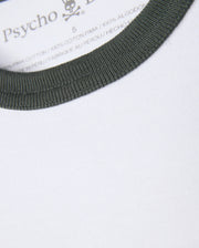 Close-up of a white heavyweight jersey tee featuring a green ribbed collar. The inside label displays the brand name "Psycho Bunny", along with the size and material information, specifying that it is crafted from 100% Pima cotton and produced in Peru. This is part of the MENS LONDON RAGLAN GRAPHIC TEE - B6U896D200 collection.
