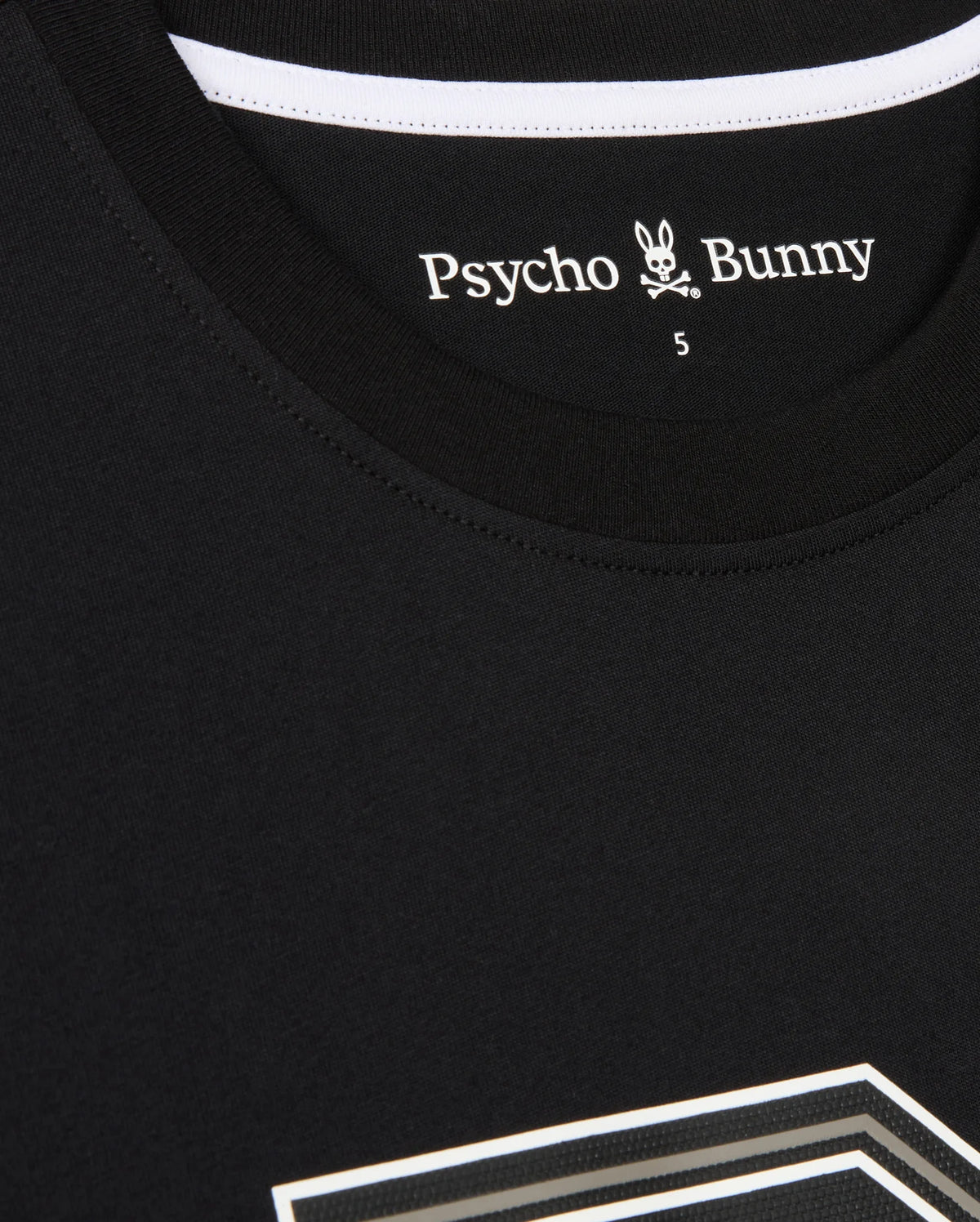 A close-up of a black MENS ZACK GRAPHIC TEE - B6U897D200 by Psycho Bunny featuring a white label inside the collar that reads "Psycho Bunny" with a small bunny logo and crossbones underneath. The number "5" is visible near the label. This Pima cotton shirt has a white stripe along the collar's inner seam.