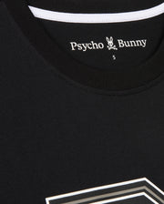 A close-up of a black MENS ZACK GRAPHIC TEE - B6U897D200 by Psycho Bunny featuring a white label inside the collar that reads "Psycho Bunny" with a small bunny logo and crossbones underneath. The number "5" is visible near the label. This Pima cotton shirt has a white stripe along the collar's inner seam.