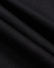 Close-up image of the Psycho Bunny MENS ZACK GRAPHIC TEE - B6U897D200 in black Pima cotton fabric with a smooth texture. The material is shown in folded layers, highlighting the softness and fine weave of the textile. The color is solid black with no visible patterns or designs.