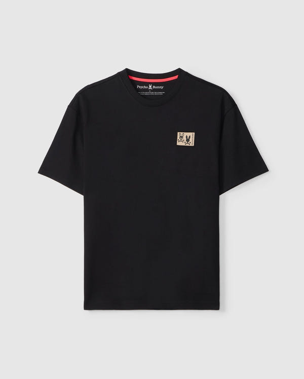 The MENS MONROE HEAVY WEIGHT RELAXED FIT TEE - B6U910D200 by Psycho Bunny is an oversized black T-shirt made from soft Pima cotton. It features a small beige patch with a striking red and black graphic on the left chest, displayed against a plain white background to emphasize its relaxed fit.