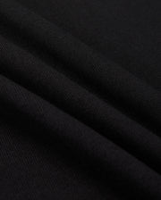 Close-up of a black fabric with a smooth texture, reminiscent of the MENS MONROE HEAVY WEIGHT RELAXED FIT TEE by Psycho Bunny. The surface displays gentle folds, showcasing the soft Pima cotton and subtle sheen.