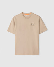 The Psycho Bunny MENS MONROE HEAVY WEIGHT RELAXED FIT TEE - B6U910D200 is a beige Pima cotton tee with a relaxed fit and crew neckline, featuring an embroidered bug emblem on the left chest.