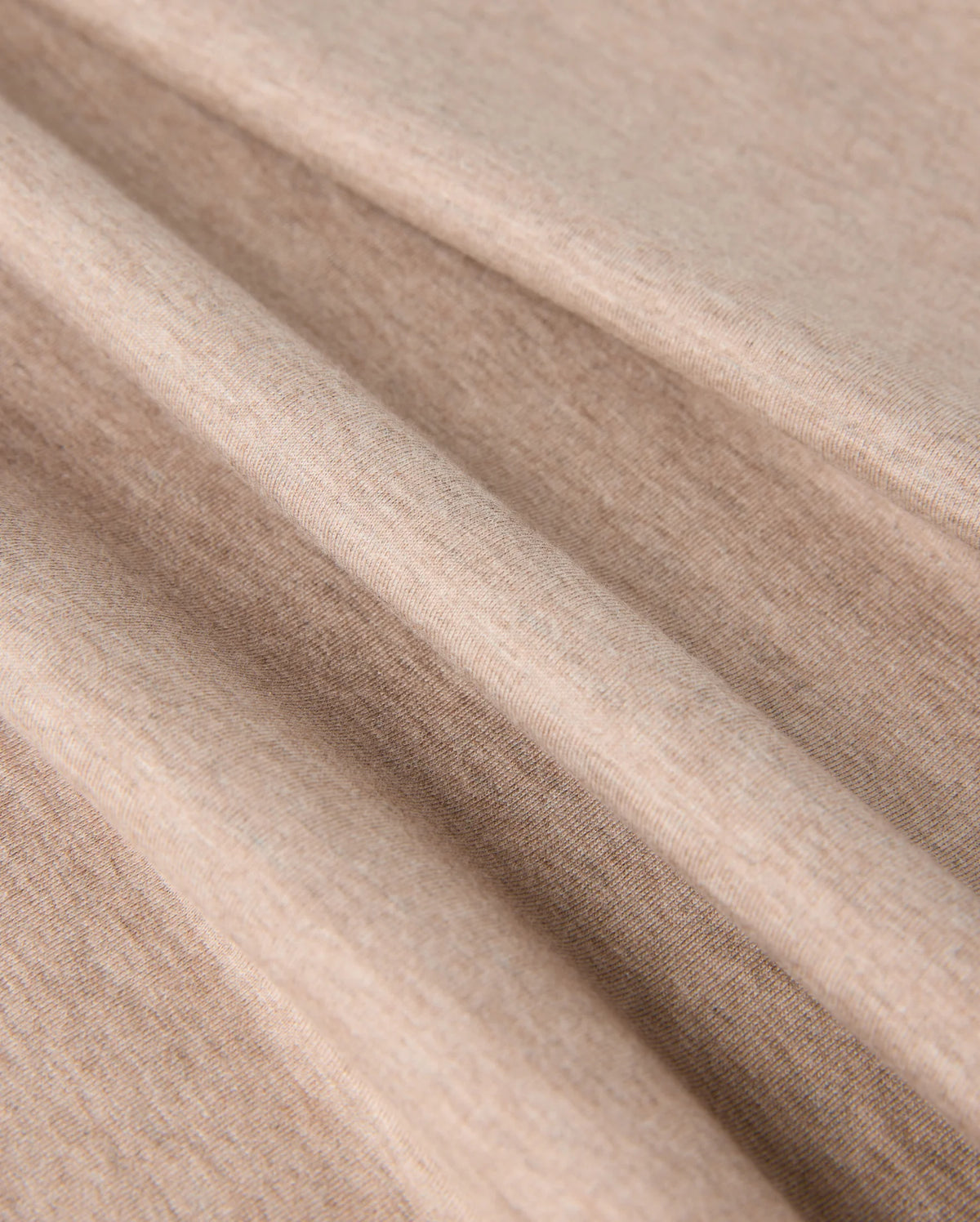 Close-up of the beige fabric with a smooth texture. The MENS JAMES PREMIUM CREW NECK TEE - B6U952D200 by Psycho Bunny is displayed in soft, loose folds, emphasizing its flexibility and softness.