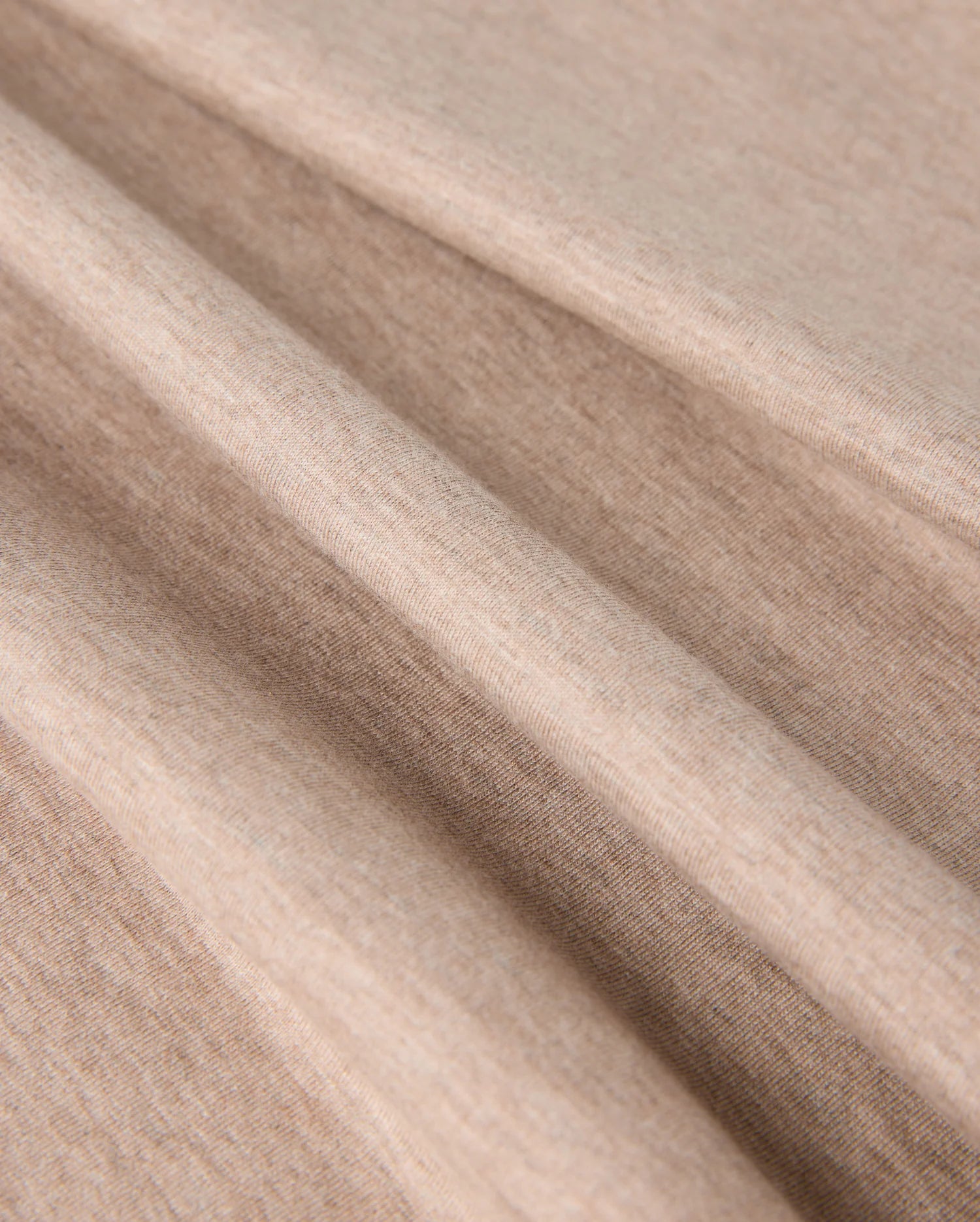 Close-up of the beige fabric with a smooth texture. The MENS JAMES PREMIUM CREW NECK TEE - B6U952D200 by Psycho Bunny is displayed in soft, loose folds, emphasizing its flexibility and softness.
