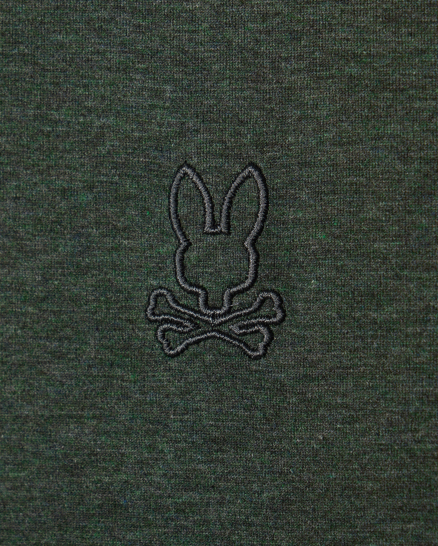 The MENS JAMES PREMIUM CREW NECK TEE - B6U952D200 by Psycho Bunny is made from high-quality Pima cotton and showcases a sophisticated dark green fabric. It features a tonal outline of their signature bunny, embroidered in black above two crossed bones, reminiscent of a skull and crossbones motif.