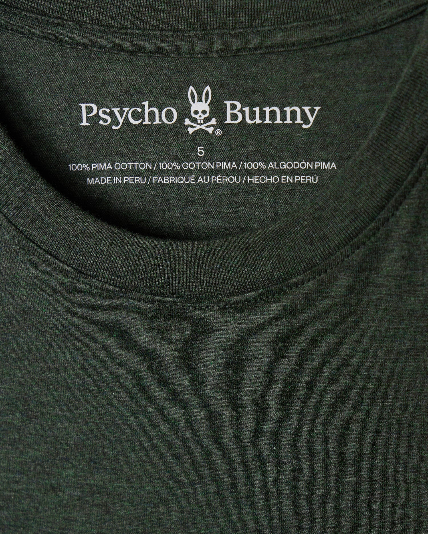 Close-up of the stylish MENS JAMES PREMIUM CREW NECK TEE - B6U952D200 in dark green, showcasing the "Psycho Bunny" label with a tonal outline bunny embroidered logo. Made from premium Pima cotton and crafted in Peru, this shirt is available in size 5.