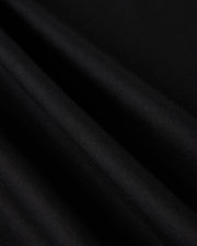 Close-up of the luxe, black fabric from the MENS MALTON FASHION TEE - B6U966D200 by Psycho Bunny, showcasing its smooth pima cotton with visible light reflections and folds, creating an elegant texture ideal for men's fashion.