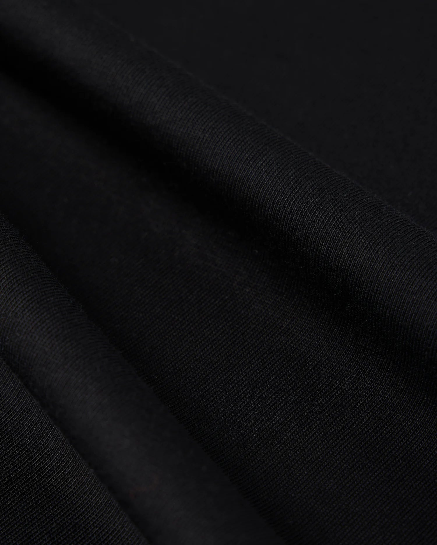 Close-up photo of textured Psycho Bunny Peruvian Pima cotton fabric, showcasing the fine weave and detail of the material.