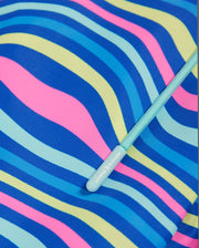 Close-up image of a colorful, wave-like pattern featuring blue, pink, yellow, and green lines on Psycho Bunny MENS CLARKSON LIGHTWEIGHT SWIM TRUNK - B6W120B2SW. A teal drawstring with a cylindrical plastic end cap is partially visible, with text reading "Always Opaska" printed on it.