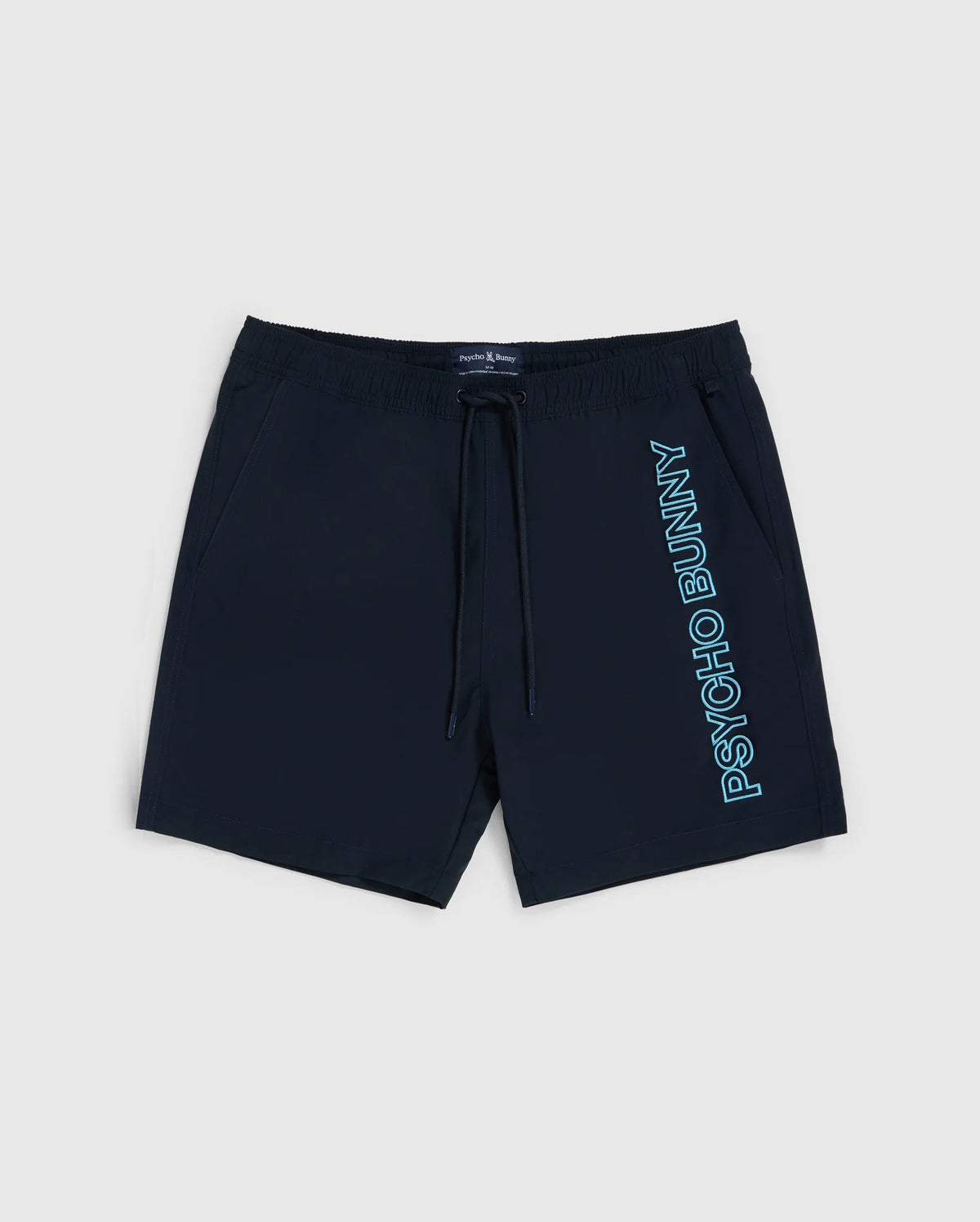 The MENS MELVIN SWIM TRUNK - B6W665C200 by Psycho Bunny are dark navy blue swim trunks featuring a drawstring stretch waistband. The quick-dry outer shell showcases the text "Psycho Bunny" written vertically in light blue on the left leg. These stylish shorts come with side pockets and are displayed on a plain white background.
