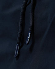 Close-up image of navy blue drawstrings on a fabric surface, with the brand name "Psycho Bunny" printed on the ends in white text. The MENS MELVIN SWIM TRUNK - B6W665C200 features a quick-dry outer shell and a comfortable drawstring stretch waistband for optimal fit and ease.
