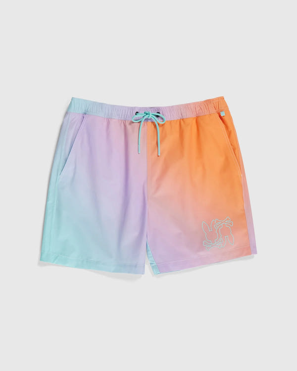 A pair of Psycho Bunny MENS WINTON PRINTED SWIM TRUNK - B6W915A2PO featuring a gradient design transitioning from light purple on the left to orange on the right. The quick-drying shorts have teal drawstrings and an embroidered design of a cartoon dog near the left hem, perfect for making a splash with style.