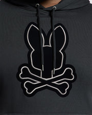 The Psycho Bunny BIG AND TALL ALEXANDER HOODIE - B9H154E200 is a black pullover hoodie featuring a stylized rabbit head with crossed bones beneath it. The design is outlined in white, providing striking contrast against the dark fabric. This comfortable hoodie is available in big and tall sizes for an ideal fit for everyone.