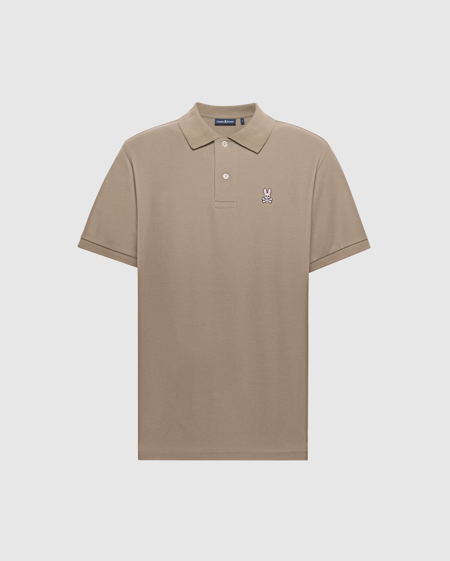 The Psycho Bunny MENS BIG AND TALL CLASSIC PIQUE POLO SHIRT - B9K001CRPC in beige features a light gray background, short sleeves, buttoned collar, and a small embroidered rabbit logo on the left chest. Crafted from soft pima cotton for elegance and comfort.