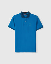 The BIG AND TALL MALTON PIQUE POLO SHIRT - B9K950D200 by Psycho Bunny features blue pima cotton with a dark blue collar, thin stripe trim on the sleeves, a three-button placket, and an embroidered rabbit logo on the chest, set against a plain white background.