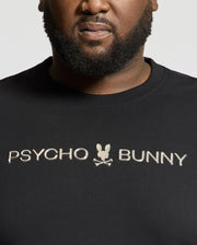 A person wears a black "Psycho Bunny" shirt with a small bunny and crossbones logo, showcasing the premium quality of the BIG AND TALL LAVATA FRENCH TERRY SWEATSHIRT - B9S159E200. The chest-up view highlights its luxurious French Terry feel.