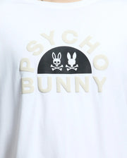 Close-up of a MENS BIG AND TALL GOLDIE GRAPHIC TEE - B9U606F200 by Psycho Bunny, crafted from Peruvian Pima cotton. It features "Psycho Bunny" in beige letters with a black half-circle displaying a white skull-and-crossbones within the bunny graphic.