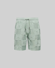 The Psycho Bunny KIDS KELVIN TOWEL TERRY SWEATSHORT - KB0900002 features light green jacquard terry cloth with a checkered bunny pattern, textured bunny faces, and an elastic drawstring waistband with metallic tips.