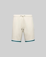 The Psycho Bunny MENS BASIL TAPED SHORT - MB0900005 in beige is made from premium cotton-modal, featuring a drawstring waist and green-blue striped accents near the hem, shown on a plain gray background.