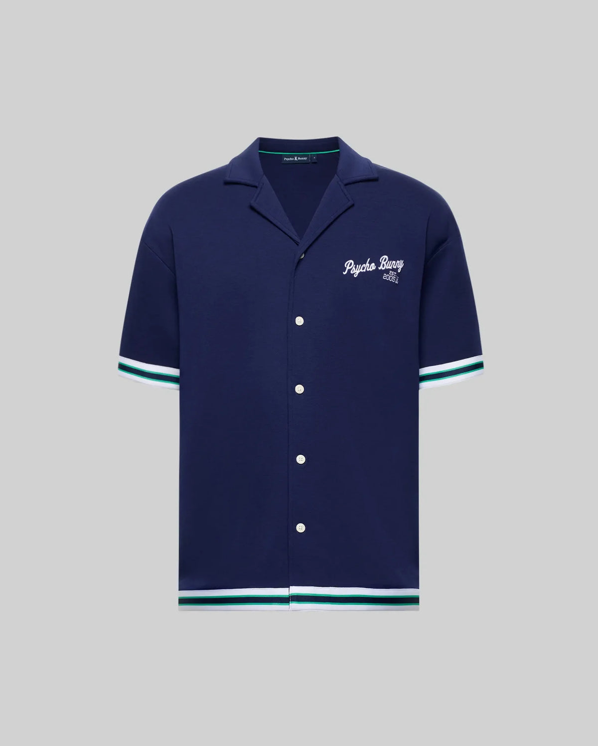 The Psycho Bunny MENS BASIL TAPED CAMP COLLAR SHIRT (MT0500004) is a navy, short-sleeve cotton-modal shirt with white buttons, white and teal striped sleeve/hem trim, and "Psycho Bunny 2005" embroidered on the left chest.