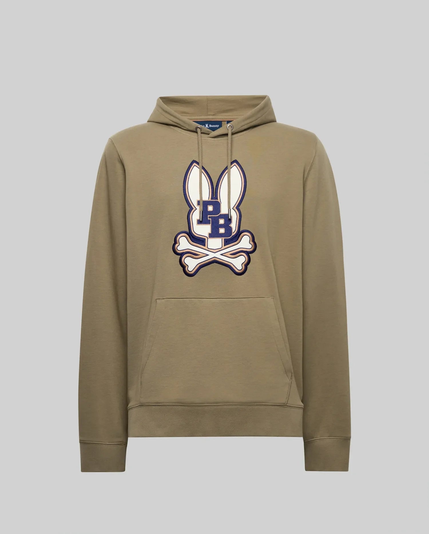 The Psycho Bunny MENS WADE HOODIE - MT0500112 is a khaki cotton-blend hoodie with white bunny ears graphic, an embroidered navy "PB" Bunny patch, white crossed bones on the chest, front pocket, and drawstrings.