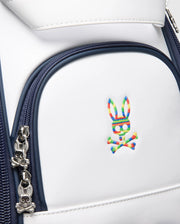 The Psycho Bunny OUTLINE BUNNY GOLF TOUR BAG - PBMG4FC1 is a white backpack with dark blue zippers, featuring colorful embroidered bunny-and-crossbones logos and bunny-shaped zipper pulls. Perfect for those seeking unique style on their adventures.