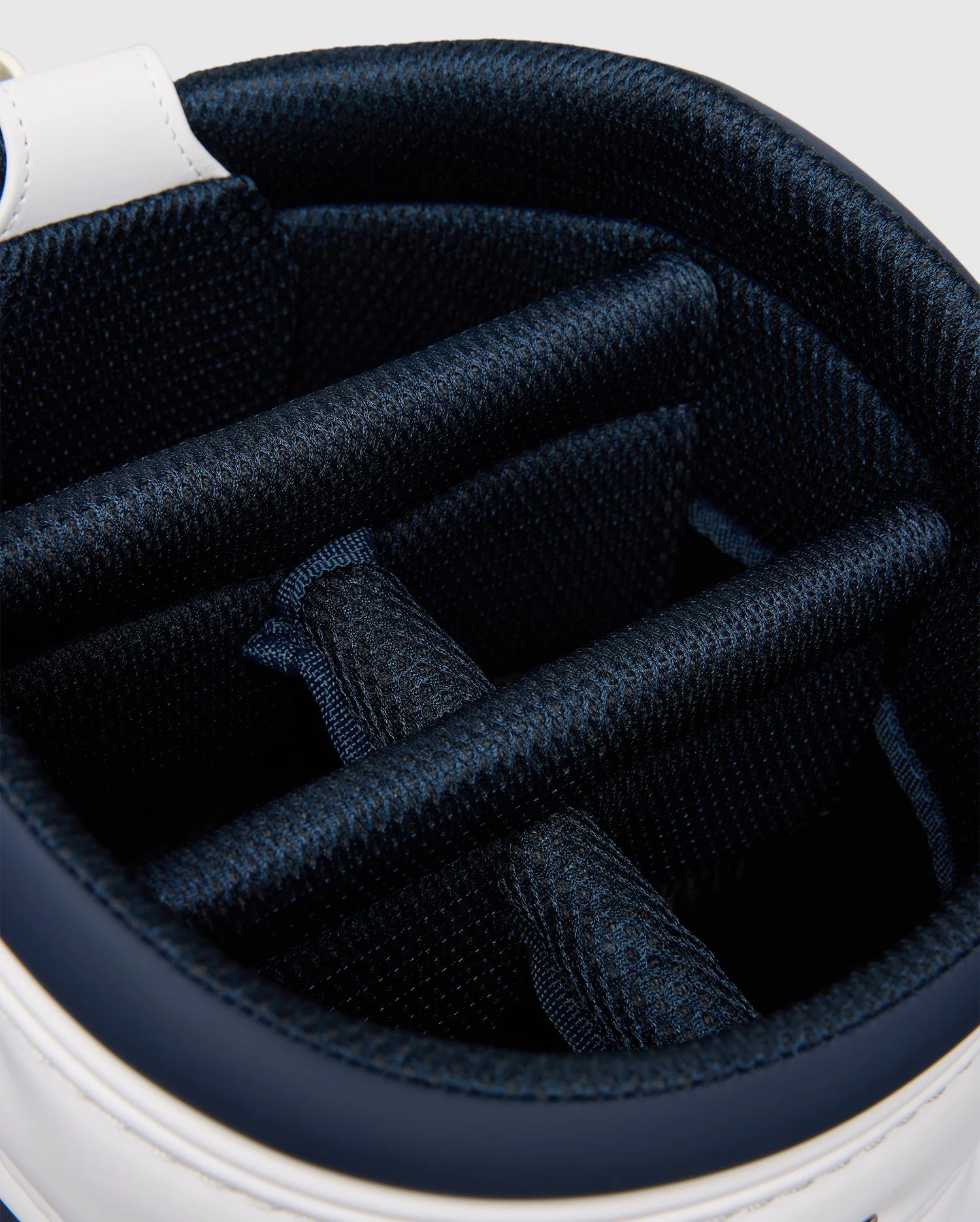Close-up of the OUTLINE BUNNY GOLF TOUR BAG - PBMG4FC1 by Psycho Bunny. Its polyurethane cart bag interior has multiple blue cushioned dividers to organize and protect clubs. The stylish outer edge is white, featuring a five-pocket design.